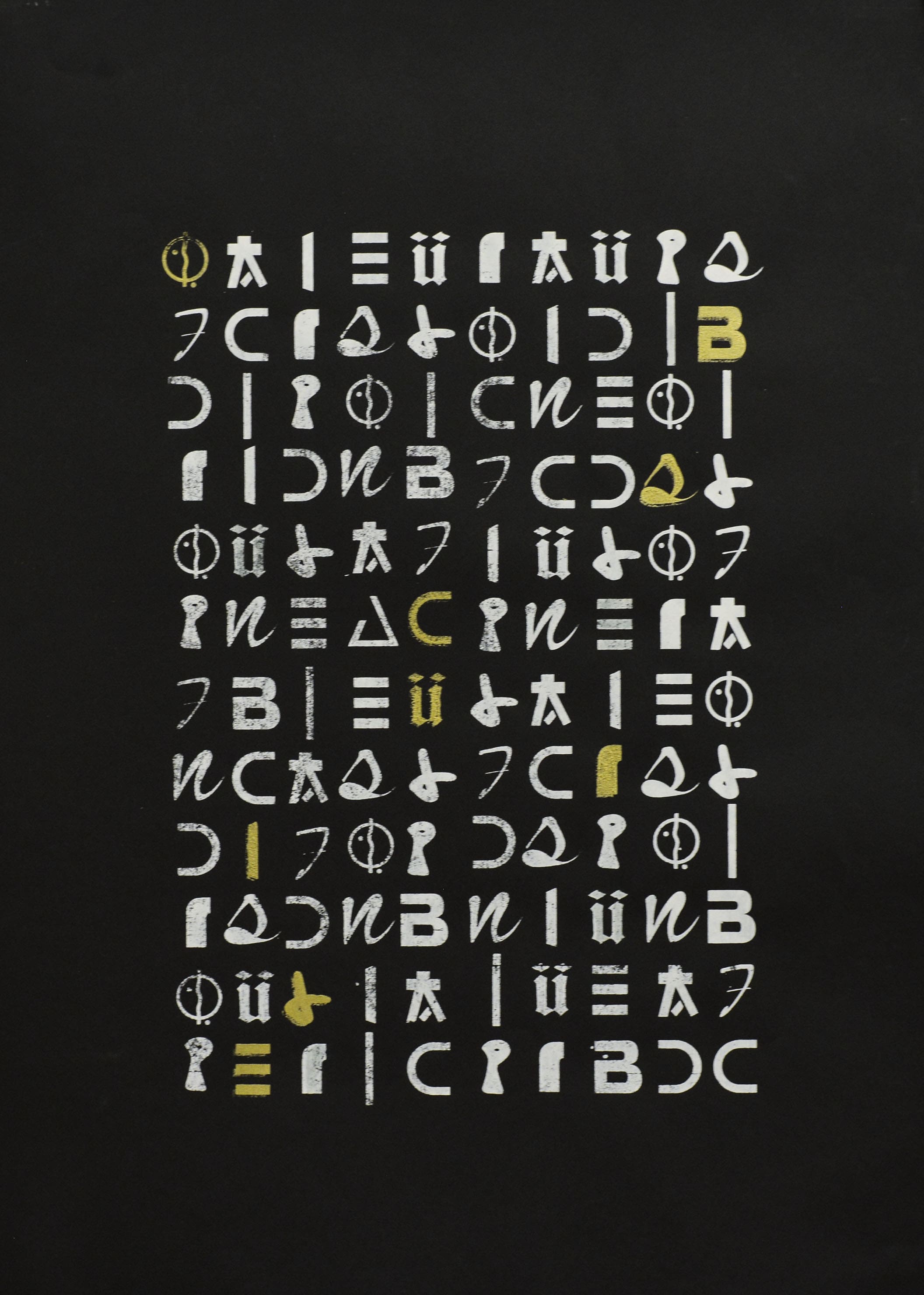 Affiche noire où l'on voit un rectangle de 10 colonnes de 12 caractères, certains sont blancs, d'autres sont en or et forment le mot 